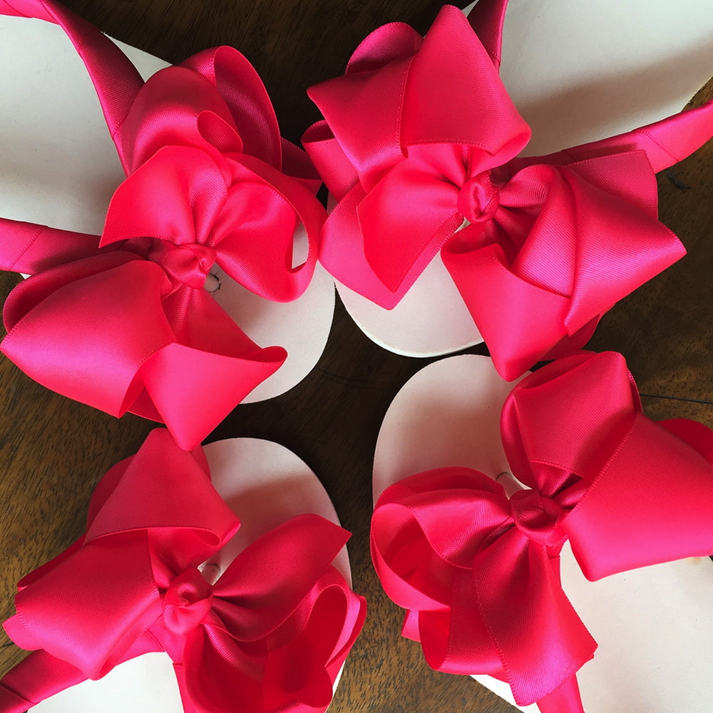 Large hot pink coloured bows on high wedge heel flip flops