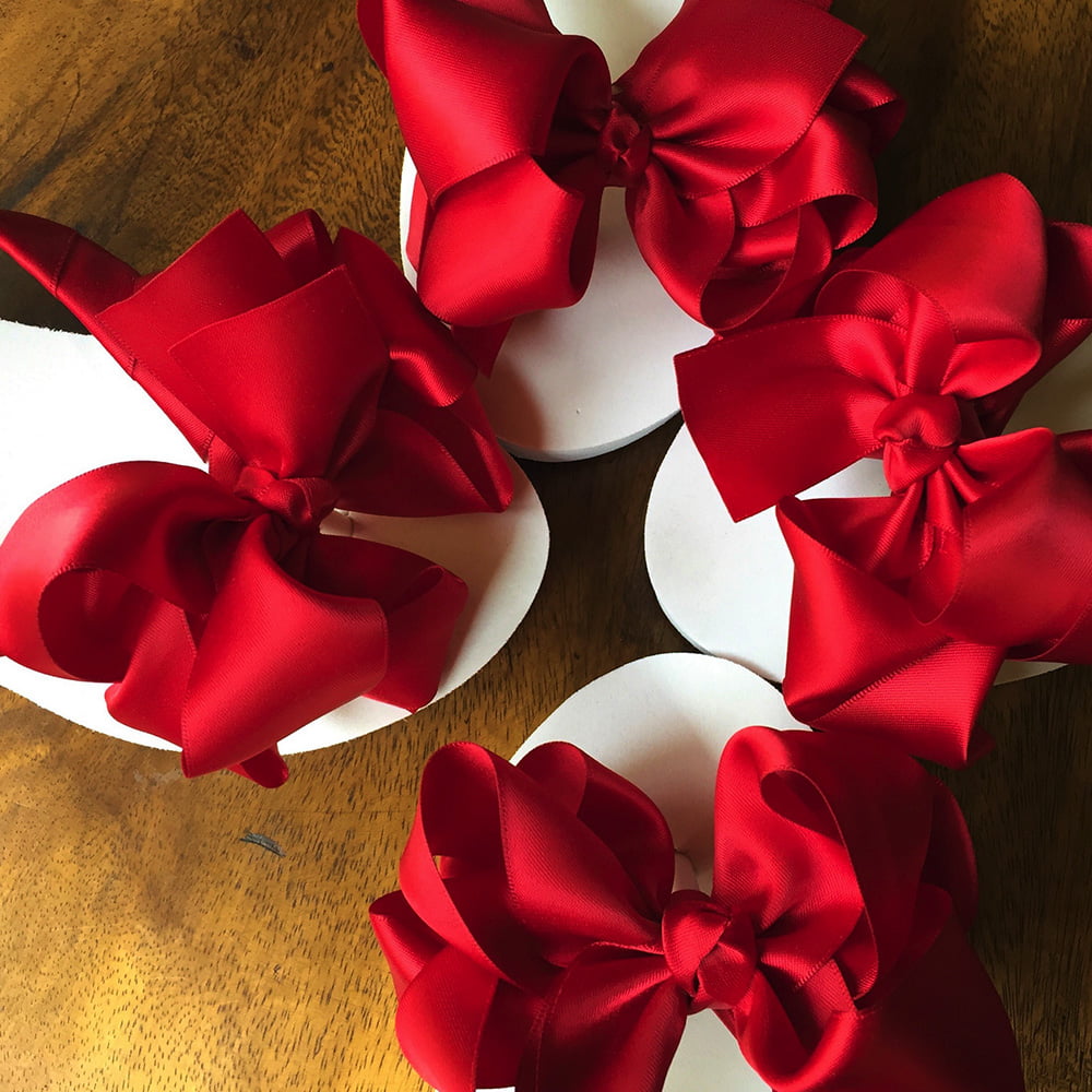 Large red coloured bows on high wedge heel flip flops