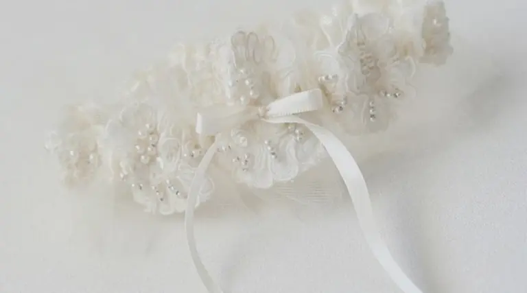 An Heirloom Wedding Garter with tiny white pearls stitched onto a beautiful lace garter